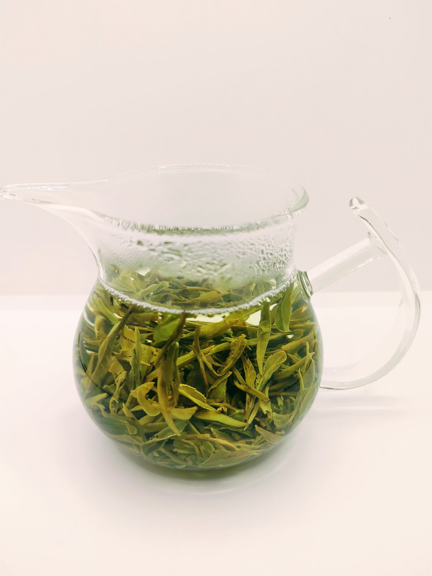 Picture of a pitcher with green tea brewing inside, Yun Wu.