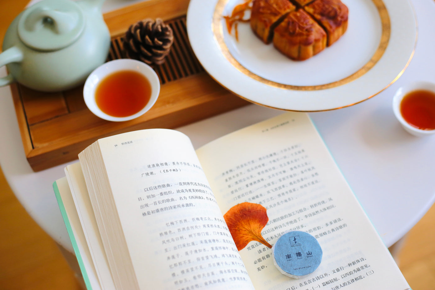 Mooncakes served with brewed tea and a white teapot.