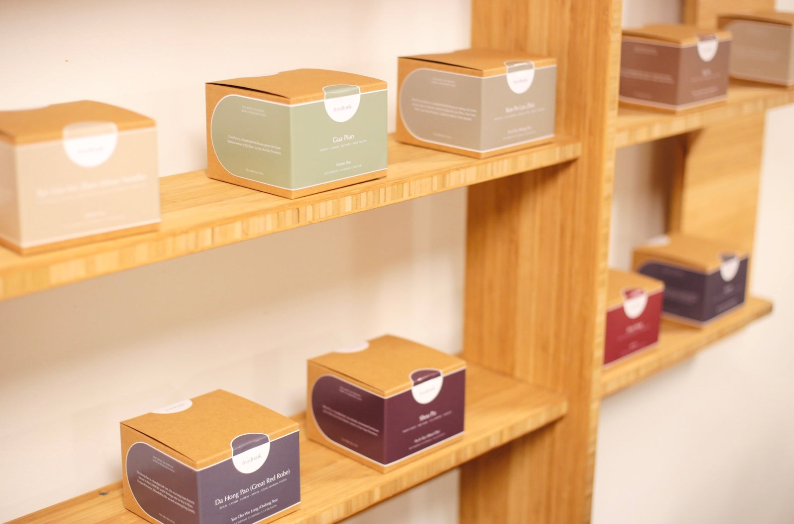 Tea Drunk gift boxes displayed on wooden shelves.