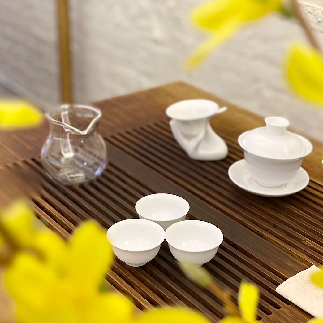 White gong fu brewing set with gai wan, fairness pitcher, and teacups.