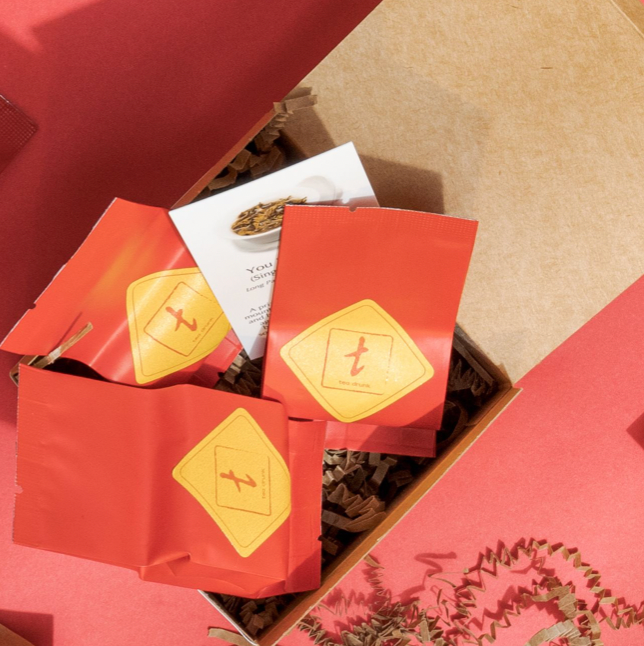 A Tea Drunk gift membership box with red tea packets.